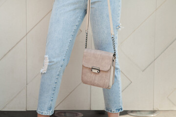 Young woman holding luxury handbag, and wearing trendy outfit. Fashion concept.