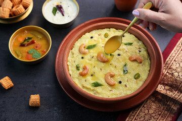 Ven Pongal Khara Pongal Sambar coconut chutney woman hand serving Indian breakfast food Tamil Nadu festival Pongal Sankranti Diwali spicy pongal using rice lentil semolina rava South India Sri Lanka