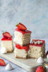 Cheesecake slice, New York style classical cheese cake with strawberry on blue background. Slice of tasty cake on white plate