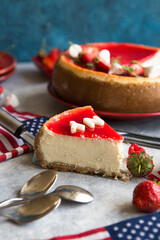 Cheesecake slice, New York style classical cheese cake with strawberry on blue background. Slice of tasty cake on white plate