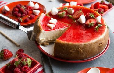 Cheesecake slice, New York style classical cheese cake with strawberry on blue background. Slice of tasty cake on white plate