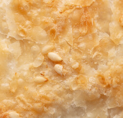 Sesame seeds on a golden brown crust of bread as a background.