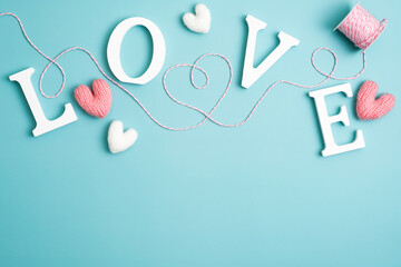 Word Love, ribbon in shape of heart, hearts on blue background. Happy Valentines day, Mothers day, birthday concept. Romantic flat lay composition