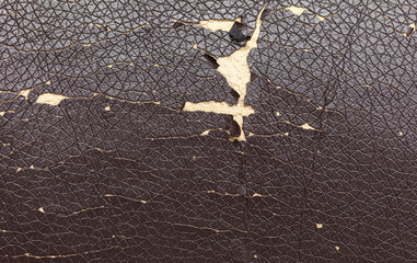 Cracked leatherette on the armchair as a backdrop.