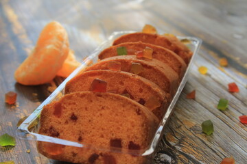 Homemade tutti frutti candied fruit sponge cake on table and colorful background for Christmas