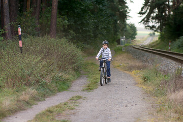 Obraz premium Little caucasian boy ride a bike. Safe sport with helmet protection.
