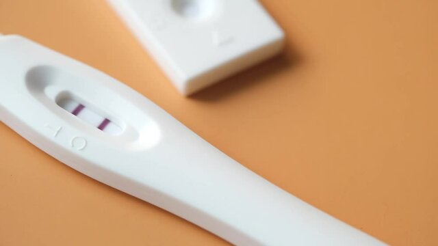 Pregnancy test kit with positive result on color background 