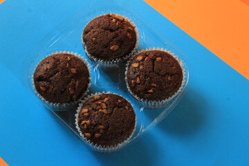 Chocolate muffin isolated on color background. Delicious chocolate muffin with nuts.