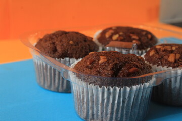 Chocolate muffin isolated on color background. Delicious chocolate muffin with nuts.