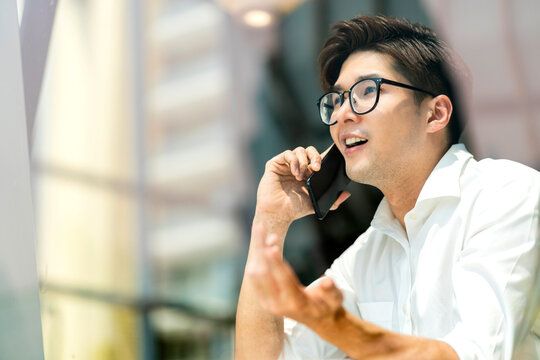 Smart attractive positive asian business male wearing glasses work remote new normal lifestyle hand use smartphone conference onlive videocall meeting remote business ideas concept shot through window
