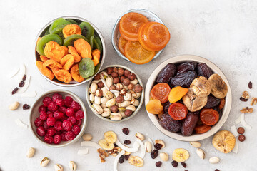 Mix of nuts and dried fruits on a  table. Dates, apricots, kiwi, peaches, figs, cherries, banana, nuts, cranberries, pistachios