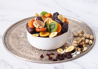 Mix of nuts and dried fruits on a  table. Dates, apricots, kiwi, peaches, figs, cherries, banana, nuts, cranberries, pistachios