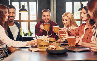 Young adults. Group of young friends sitting together in bar with beer