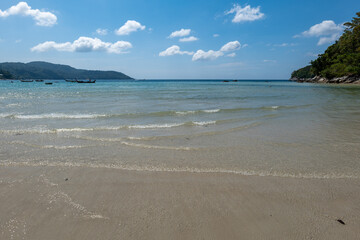 Kata beach in Phuket, Thailand, beach with clear water, white and golden sand, blue sky, in tropical vacation area.  a beach holiday  photo with copyspace.