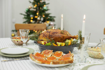 Obraz na płótnie Canvas A festive New Year's table, on the table a Christmas turkey with oranges, aromatic herbs and cranberries