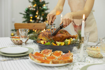 Fototapeta na wymiar A festive New Year's table, on the table a Christmas turkey with oranges, aromatic herbs and cranberries