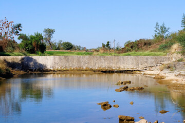 Beautiful landscape of Check Dams In The Gir forest Forest Gujarat India. Lake shore with tree branches. also cold lacustrine. and clear blue sky, small river in rural areas Stock Photos and Images