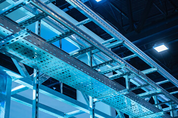 Suspended trays for electrical communication. Perforated trays of metal. Construction for laying wires and utilities. Place for electrical wires under hangar roof. Concept installation of utilities