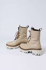 Beautiful beige shoes with genuine leather on an isolated white studio background. Fashionable classic women's boots. Stylish elegant leather shoes.