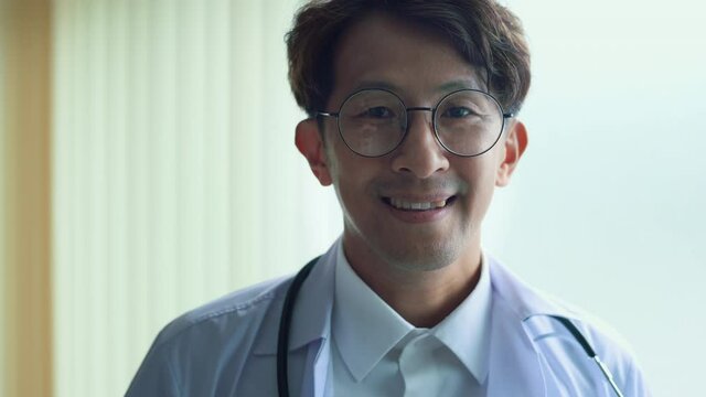 Portrait of confident smiling doctor wearing white coat in hospital