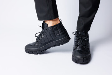 Men's black boots made of genuine leather, men's footwear on a white background. Winter men's shoes 2022