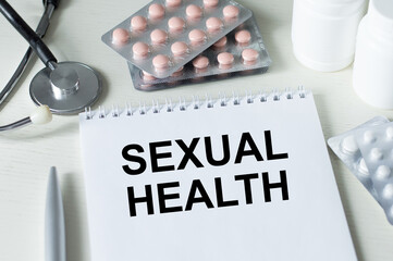 Text Sexual Health on a notebook on an office desk next to a stethoscope, tablets