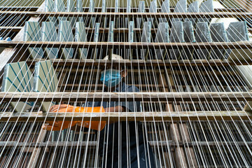 SIDEMEN/BALI-SEPT 03 2021: A tile factory worker in Sidemen village, Karangasem, Bali, is drying patterned tiles on a traditional rope dryer. So that this tile becomes completely dry