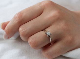 Jewelry background. Diamond ring on woman hand
