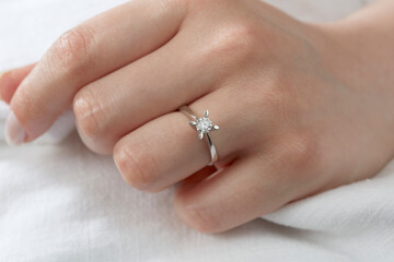 Jewelry background. Diamond ring on woman hand