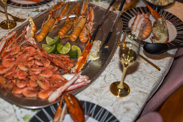 Close up view of a man who lays out seafood dishes in plates on table. Sweden.