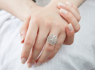Jewelry background. Diamond ring on woman hand