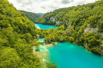 Fototapeta na wymiar Last sunlight lights up the pure water waterfall on Plitvice National Park. Colorful spring panorama of green forest with blue lake. Great countryside view of Croatia, Europe.