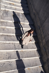 Top view of young African-American businesswoman going down the stairs