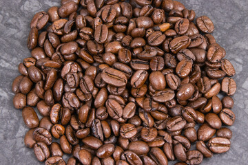 Heap of roasted fragrant coffee grains. Structure concrete