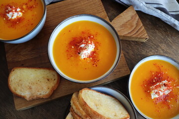 Freshness pumpkin creamy soup for autumn dinner on rustic table