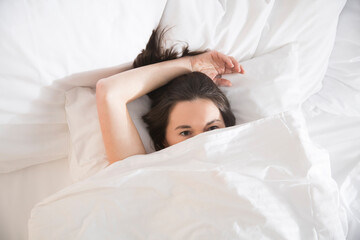 Obraz na płótnie Canvas woman lying in bed under a blanket. insomnia. Healthy sleep. 