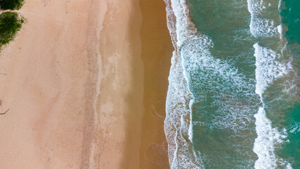 praia com águas cristalinas e ondas vista de drone