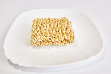 Instant noodles on a white plate. Fast food.