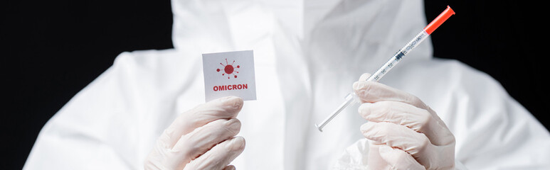partial view of scientist in latex gloves holding syringe and card with omicron lettering isolated...