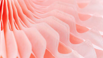 Abstract coral background with perspective macro photography. Pink background with geometric shapes. Detail of a paper fan close-up.