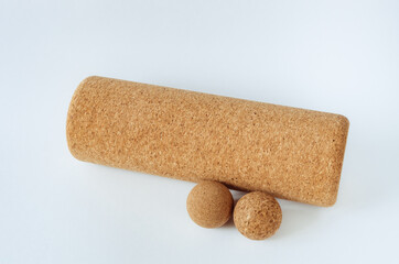 Close up of isolated props for myofascial release, yoga therapy:cork massage balls, cork roller on a white background. Concept: self care practices at home, sustainable, eco-friendly props.