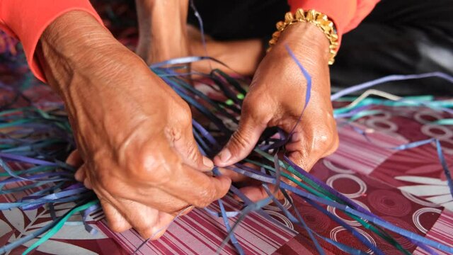 Bajau people weaving a traditional mat with a pandan straw leaves at Sabah.