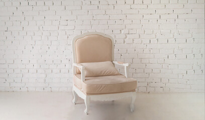 Beige armchair in the interior. . Light stylish modern interior.