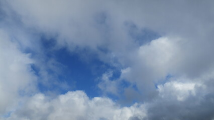 Obraz premium White cloud field with interesting shapes in the blue sky on a sunny day with space for a message