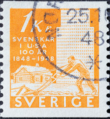 Sweden - circa 1948: a postage stamp from Sweden showing a farmer with a plow in front of an antique house. Emigration from Sweden to the USA . orange