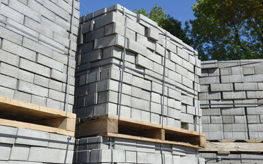 Concrete bricks for construction are stacked on a pallet in even rows.