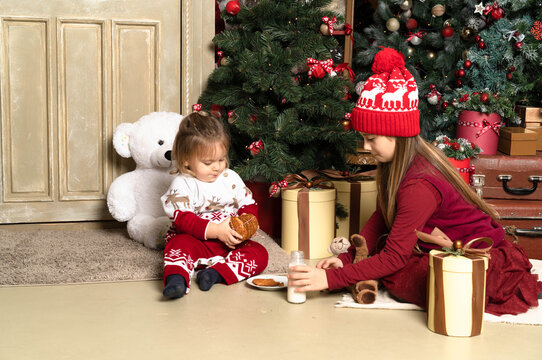 Sister and brother baby in red Christmas clothes and winter sweaters and open New Year's gifts .Horizontal photo for christmas, father day, xmas.