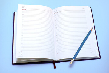 Diary on a holoboom background open on a blank page next to it lies a pencil