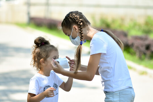 A teenage girl takes care of her younger sister.