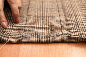 The dressmaker will open the fabric for the future costume for further work. Fashion designer tailor in the workshop of the studio, developing a new collection of clothes. 